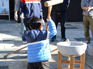 画像：１月イベントお餅つき大会（餅をつく子供）